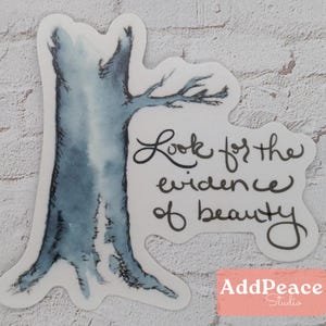 May include: A watercolor illustration of a bare tree with the text "Look for the evidence of beauty" in black cursive writing.