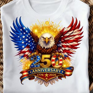 May include: White t-shirt with a graphic of an American bald eagle, wings in red, white, and blue. The design includes the text "250 Anniversary 1776-2026" on a banner, celebrating a milestone.