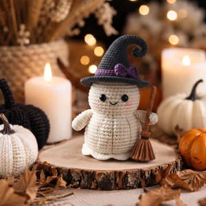 Peut inclure: Une figurine de fantôme au crochet de couleur crème, portant un chapeau de sorcière pointu gris foncé avec un ruban et un nœud violets. Le fantôme a des yeux en perles noires, un petit sourire brodé et tient un balai en fil marron.