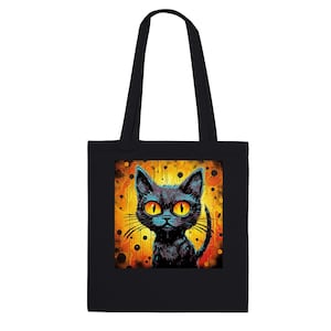 Könnte beinhalten: Schwarze Tragetasche mit einer farbenfrohen Illustration einer schwarzen Katze mit großen gelben Augen. Die Katze ist vor einem gelb-orangen Hintergrund mit einem strukturierten Design platziert. Die Tasche hat schwarze Griffe.