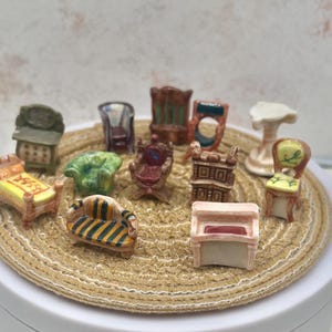 May include: A collection of miniature furniture pieces, including chairs, a bed, a sofa, and a piano. The furniture is painted in various colors and styles, arranged on a round, woven surface.