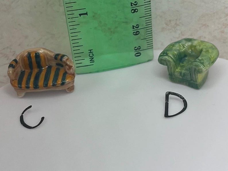 May include: Miniature furniture set including a striped sofa and a green armchair. The sofa is approximately 1 inch long. Also included are two black metal letter charms, a "C" and a "D".