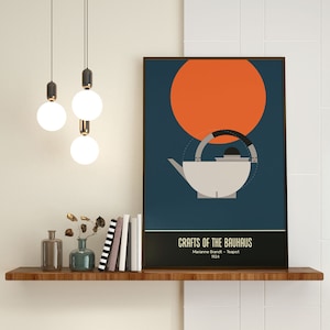 May include: A poster with a blue background and a large orange circle. The poster features a black and white illustration of a teapot with the text "Crafts of the Bauhaus Marianne Brandt - Teapot 1924".