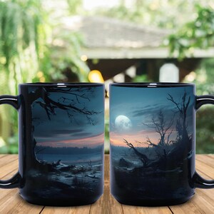 May include: Two black ceramic mugs with a nighttime forest scene printed on them. The scene features a full moon, trees, and a lake. The mugs are 15 ounces each.
