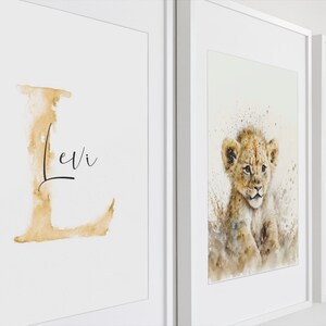 Personalisierte Wandbilder mit Kinderzimmer-Charme: Ein einladendes Set aus drei gerahmten Postern. Das erste zeigt ein verspieltes "L" mit dem Namen "Levi", das zweite ein bezauberndes Löwenjunges in Aquarell, und das dritte inspiriert mit der Botschaft "Sei frech, wild und wunderbar". Perfekte Dekoration für ein liebevolles und kreatives Kinderzimmer.