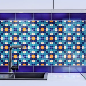 May include: A black kitchen faucet with a modern design is mounted above a black sink. The backsplash behind the sink is a mosaic of blue, white, and orange tiles.