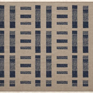 May include: A rectangular rug with a geometric design. The rug has a beige backdrop with a grid of navy blue rectangular shapes. The symmetrical design creates a modern look. The rug is made of a woven material, suitable for a living space.