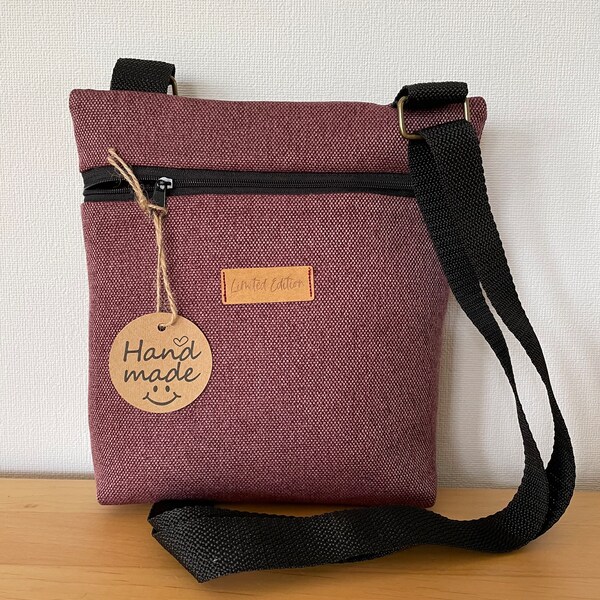 Small berry-colored crossbody bag made of fabric for strolling through town, going to a restaurant or going to a concert