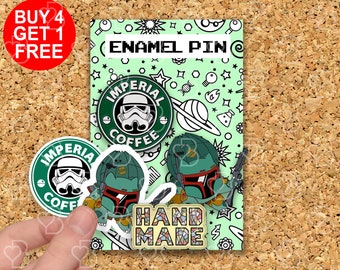 Peut inclure: Trois épingles en émail représentant un logo de tasse à café vert et blanc avec le texte "Imperial Coffee" et une image de dessin animé d'un Stormtrooper. Le logo est entouré d'étoiles et de planètes. Les épingles sont sur un fond vert avec une bordure blanche et le texte "Enamel Pin" et "Handmade".