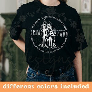 Puede incluir: Camiseta negra con un dise&ntilde;o gr&aacute;fico blanco de un caballero con armadura sosteniendo una espada. El gr&aacute;fico incluye el texto "Sean fuertes en el Se&ntilde;or y en su poder. P&oacute;nganse la armadura completa de Dios para que puedan resistir los planes del diablo."