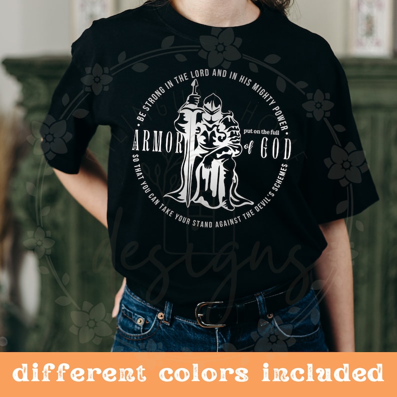 Puede incluir: Camiseta negra con un dise&ntilde;o gr&aacute;fico blanco de un caballero con armadura sosteniendo una espada. El gr&aacute;fico incluye el texto "Sean fuertes en el Se&ntilde;or y en su poder. P&oacute;nganse la armadura completa de Dios para que puedan resistir los planes del diablo."