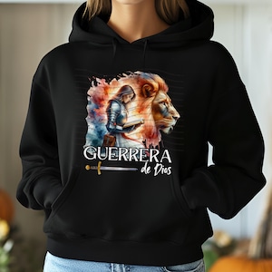 May include: Black hoodie with a watercolor illustration of a woman in armor holding a book, a lion, and the text "GUERRERA de Dios".