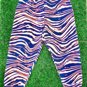 May include: Blue and white striped pants with a red wavy pattern. The pants have a drawstring waistband and a relaxed fit.
