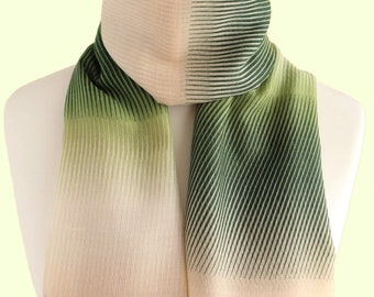 May include: A rectangular scarf featuring a gradient pattern that transitions from a light cream colour to a deep forest green. The design consists of fine, vertical lines that vary in density, creating a striped effect across the fabric surface.
