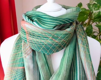 May include: A green and orange striped scarf with a geometric pattern. The scarf is made of a soft, lightweight fabric and is perfect for adding a touch of colour to any outfit.