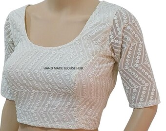 May include: White embroidered blouse with a scoop neck and short sleeves. The blouse has a geometric pattern and the text "HAND MADE BLOUSE HUB" is printed on the front.