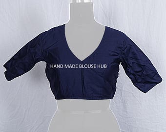 May include: A navy blue blouse with a deep V-neck and three-quarter sleeves. The blouse is displayed on a mannequin and features the text "HAND MADE BLOUSE HUB". The fabric appears to have a slight sheen.