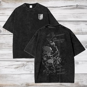 May include: Black t-shirt with a faded look. The front of the shirt has a small graphic of the Attack on Titan logo. The back of the shirt has a larger graphic of a character from the show with the text "13th commander of the survey corps. Titans really are incredible."