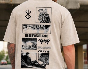 以下が含まれることがあります： ベージュ色のTシャツ。黒いマンガ風パネルのデザインで、「BERSERK」の文字と日本語の文字、「GUTS」の文字が描かれています。ゆったりとしたフィット感のTシャツです。