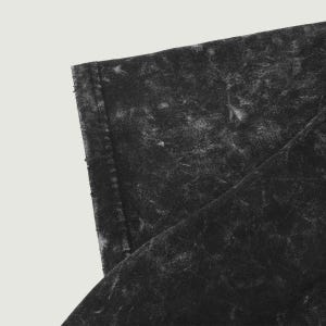 May include: Close-up of a black, distressed, cotton fabric with a subtle texture. The fabric has a faded, vintage look.