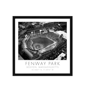 May include: Black and white framed print of Fenway Park, Boston, Massachusetts, an aerial view of the baseball stadium filled with spectators. The print includes the stadium's name and coordinates.