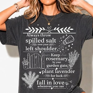 Puede incluir: Una camiseta gris carbón con gráficos de líneas blancas y el texto: Always throw spilled salt over your left shoulder, Keep rosemary by your garden gate, plant lavender for luck, fall in love whenever you can.