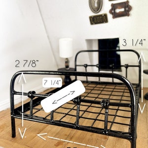 May include: Black metal bed frame with a wire mesh design. The bed frame measures 5 inches wide, 7 1/4 inches long, and 2 7/8 inches tall.
