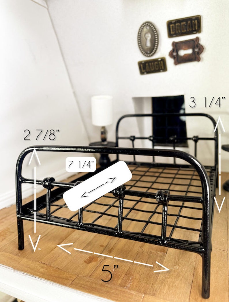 May include: Black metal bed frame with a wire mesh design. The bed frame measures 5 inches wide, 7 1/4 inches long, and 2 7/8 inches tall.