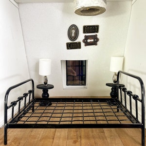 May include: A black metal bed frame with a white ceiling fixture and decorative wall art with the words "Dream", "Laugh", and a keyhole design.
