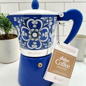May include: A blue and white 6-cup Italian coffee maker with a floral design. The coffee maker has a blue handle and lid, and a silver base. The brand name "BRANDANI" is visible. The tag reads "Italian Coffee Coffee Maker".