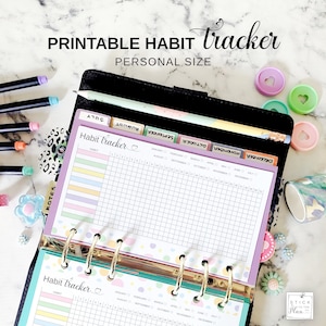 Può includere: Un raccoglitore personale nero con un tracker delle abitudini stampabile. Il tracker ha una griglia per le voci giornaliere e strisce pastello colorate. Il testo "PRINTABLE HABIT tracker PERSONAL SIZE" è visibile.