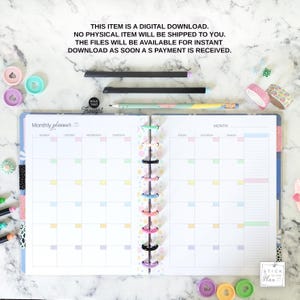Puede incluir: Un planificador mensual de colores pastel con encuadernaci&oacute;n en espiral, abierto a un dise&ntilde;o mensual en blanco. El planificador incluye pesta&ntilde;as coloridas y est&aacute; acompa&ntilde;ado de bol&iacute;grafos, cinta washi y clips decorativos. El texto en el planificador dice "Monthly planner".