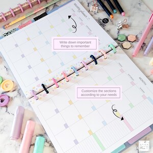 Puede incluir: Planificador mensual abierto con pesta&ntilde;as coloridas y encuadernaci&oacute;n en espiral. El planificador presenta un dise&ntilde;o de calendario con casillas de colores pastel y texto que dice "Escribe cosas importantes para recordar" y "Personaliza las secciones seg&uacute;n tus necesidades."