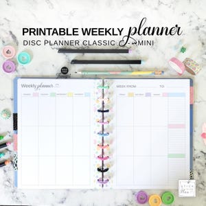 Puede incluir: Una agenda semanal de discos imprimible con diseño clásico y mini. La agenda abierta presenta páginas blancas con encabezados de colores pastel para los días de la semana, un lomo de discos central y el texto PRINTABLE WEEKLY planner DISC PLANNER CLASSIC - MINI.
