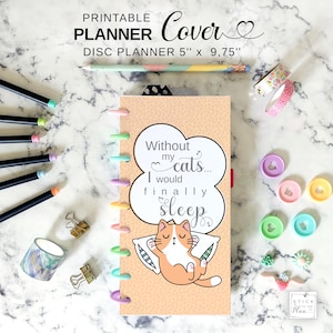 May include: A disc planner cover with the text "Without my cats... I would finally sleep" and a cartoon cat illustration. The planner is 5" x 9.75" and has colorful disc binding. Additional stationery items include pens, washi tape, and binder clips.