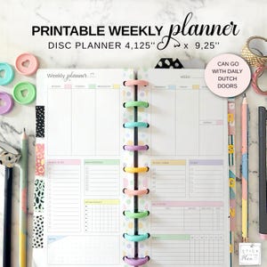May include: A pastel-colored disc planner with the text "PRINTABLE WEEKLY planner DISC PLANNER 4.125" x 9.25"" is open to display the weekly layout. The planner has colorful dividers and a spiral binding with various colored rings. The planner includes sections for notes, to-do lists, and appointments.