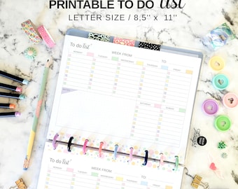 May include: A printable to-do list with the text "PRINTABLE TO DO list LETTER SIZE / 8,5" x 11"" is open on a marble surface. The list is divided into days of the week with checkboxes. Colorful washi tape, pencils, and binder clips are scattered around.