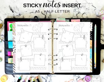 May include: A black binder with a white page insert for sticky notes. The insert has a marble pattern and a floral design. The text "Sticky notes insert" and "A5 - Half Letter" is printed on the page.