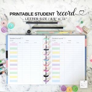 May include: A printable student record notebook with the text "PRINTABLE STUDENT record" and "LETTER SIZE / 8,5" x 11". The notebook is open, showing lined pages with pastel-colored sections. Pens, washi tape, and decorative paper clips surround the notebook.