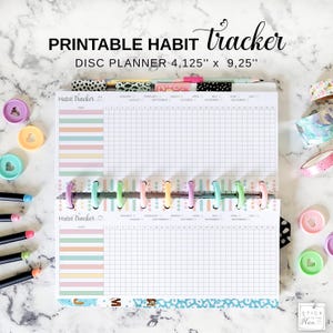 Puede incluir: Un planificador de discos de seguimiento de hábitos imprimible con un diseño de cuadrícula para rastrear hábitos. El planificador mide 10,48 cm por 23,50 cm y presenta divisores y anillos coloridos. Las palabras "Printable Habit Tracker" están en la parte superior.