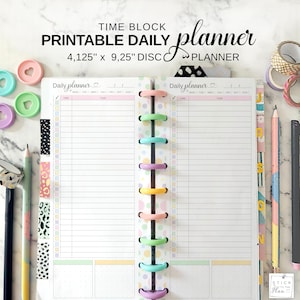 May include: A printable daily planner with the text "TIME BLOCK PRINTABLE DAILY planner" and the dimensions "4.125" x 9.25" DISC PLANNER." The planner is open, showing lined pages with a colorful disc binding. Accessories include pencils, washi tape, and decorative paper clips.