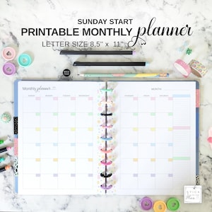 May include: A printable monthly planner with the text "SUNDAY START PRINTABLE MONTHLY planner LETTER SIZE 8.5" x 11"" is open to a blank monthly calendar. The planner is held together with colorful rings. Pens, washi tape, and decorative paper clips are scattered around the planner.