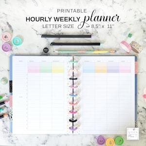 Peut inclure: Un planificateur hebdomadaire horaire imprimable, format lettre 21,6 cm x 27,9 cm, avec des sections aux couleurs pastel pour chaque jour. Le planificateur est ouvert, montrant la mise en page hebdomadaire, avec des stylos et des éléments décoratifs.