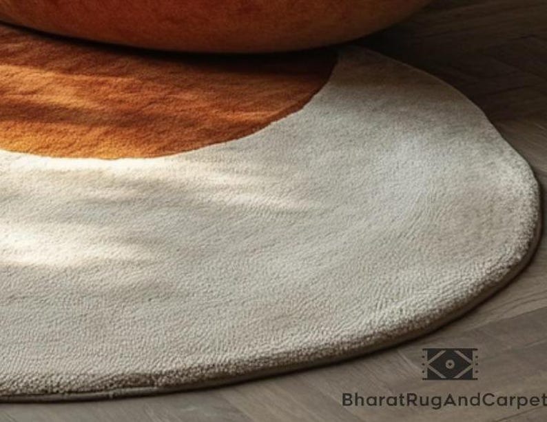 May include: A round, cream-colored rug with a half-circle of brown fur in the upper portion.