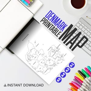 May include: A black and white printable map of Denmark with the text "DENMARK PRINTABLE MAP". The map is labeled with the names of the regions. The image also includes a printer, keyboard, coffee cup, and colorful markers.