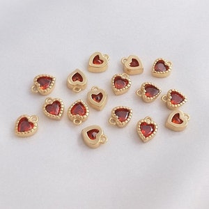 Puede incluir: Una colecci&oacute;n de 15 dijes de coraz&oacute;n de oro con acentos de vidrio rojo. Los dijes tienen un bucle en la parte superior para sujetarlos a joyas u otras manualidades.