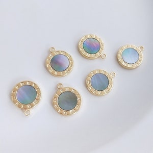 May include: Six gold-tone round pendants with a blue and green iridescent shell inlay and Roman numeral markings around the edge.