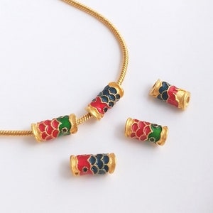 May include: Gold chain necklace with four colourful enamel beads. Each bead features a red, green and blue fish scale pattern.