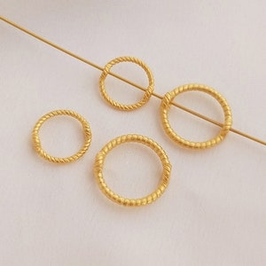 Puede incluir: Cuatro anillos de metal de color dorado de diferentes tamaños. Los anillos son todos de diseño retorcido o en forma de cuerda.