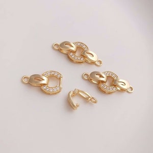 May include: Four gold-toned metal clasps with clear crystal embellishments. The clasps are designed to be used for jewelry making.